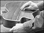 John Greven French polishes the back of a guitar