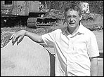 Michael Sanden stands next to a log that has been cut into two foot sections