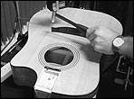 A guitar top being tested by smacking it with a plastic tipped hammer and a the response being noted by a laser displacement sensor (Keyence LK-G82)