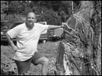 Mike Brittain stands next to the main trunk of a 50 year old rosewood tree in Florida