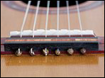 Michael Grossman uses decorative beads to anchor strings on a classical guitar bridge