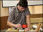 James Condino applies needlepoint backing fabric for added strength during a upright bass restoration