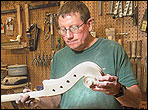 Roger Alan Skipper inspects a upright bass neck