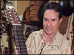 Manuel Diaz shows off a unusual guitar in his shop