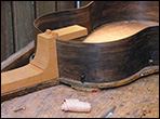 Guitar sides on a workboard with neck and end block being attached