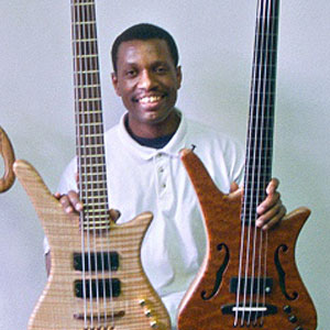 Photo of David Minnieweather holding two of his basses