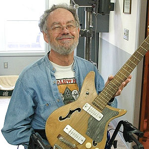 Picture of Dennis Stevens holding a electric guitar