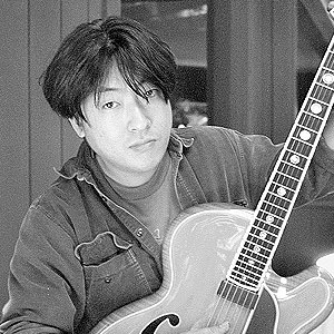 Picture of Taku Sakashta with one of his guitars