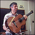 Jose Romanillos holding a Kasha/Schneider guitar