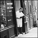 Bernard Millant examining a violin in natural light outside of his Paris shop in 1989