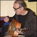 Jim Kelly plays a guitar by Tom Knatt.