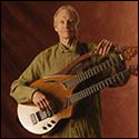 William Eaton holding a recent double neck harp guitar with Transperformance tuning system